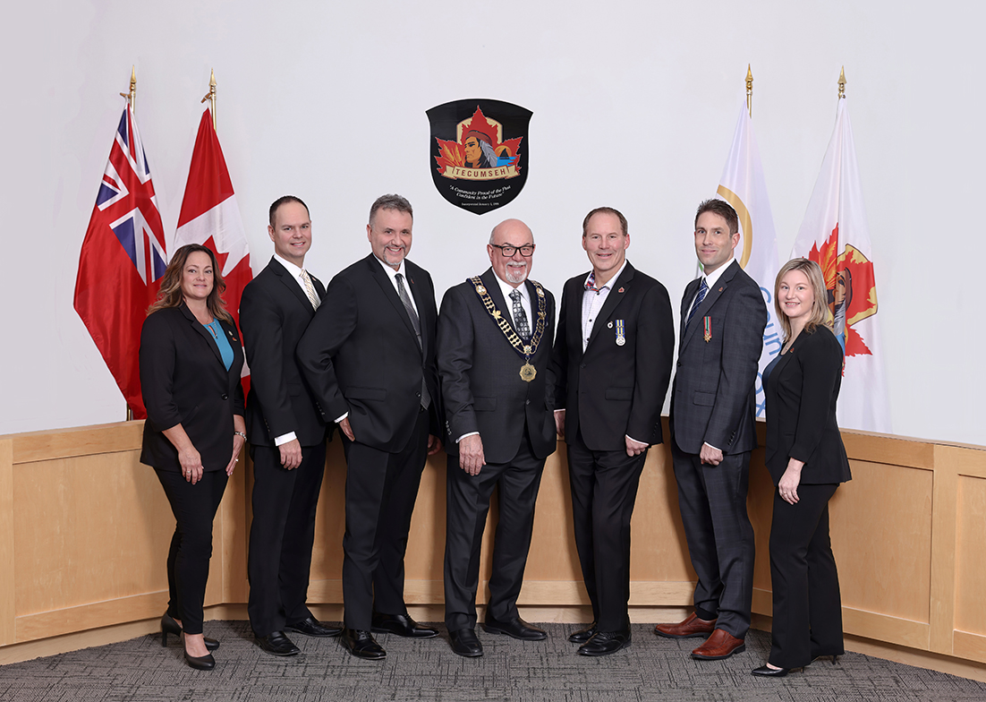 Members of Tecumseh Council in Council Chambers with flags in the background